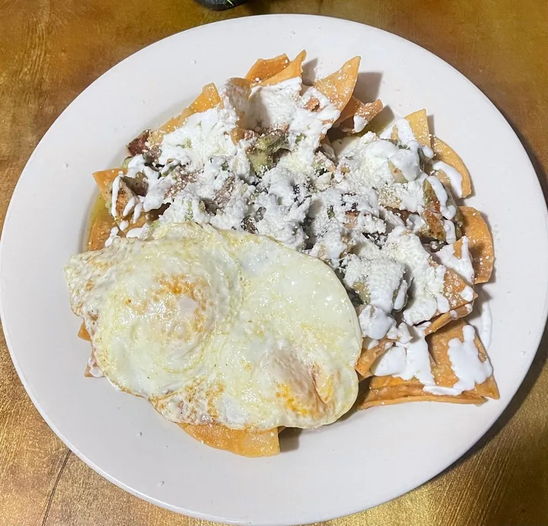 Chilaquiles topped with fried egg, crema, and fresh cheese