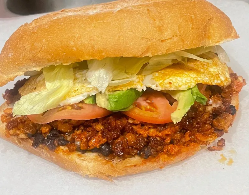 Chorizo torta with egg, avocado, and fresh toppings