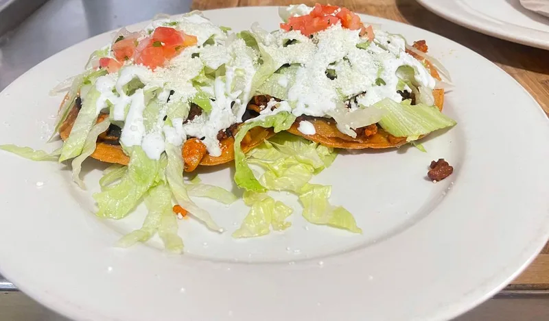 Crispy tostadas topped with crema and fresh ingredients